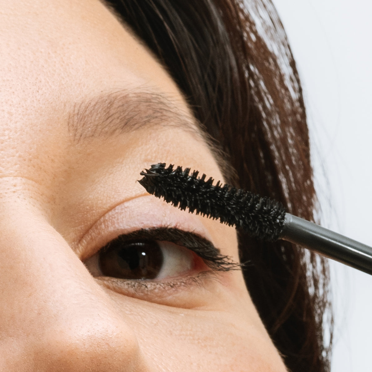 Application de l'Upcils sur les cils supérieurs en gros plan sur l'œil, mascara L'Atelier du Sourcil
