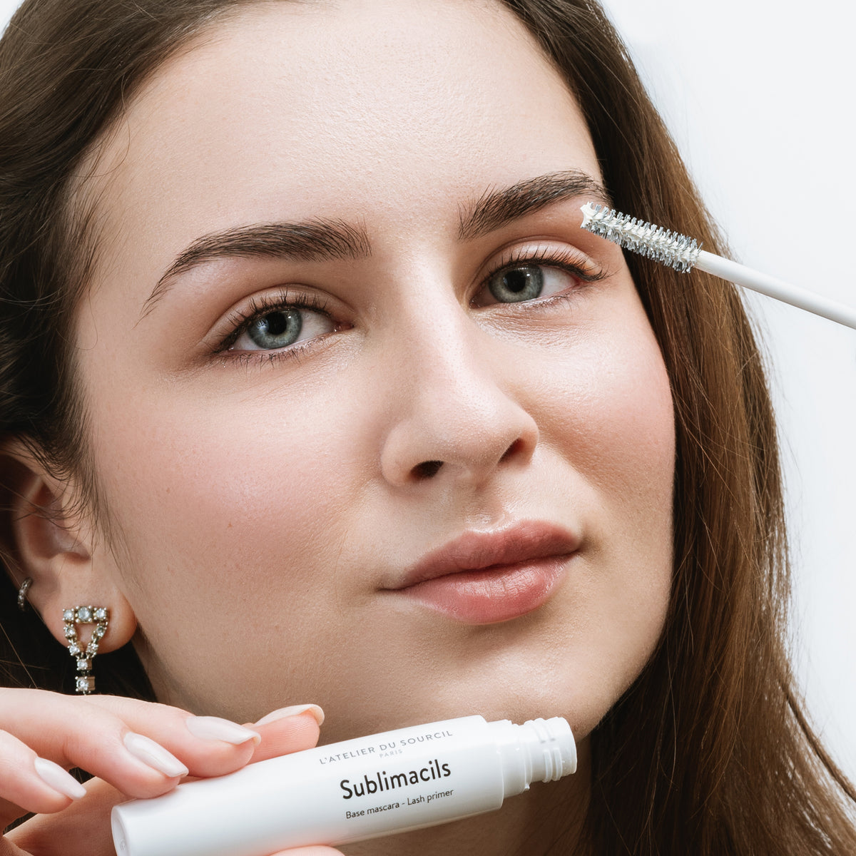 Sublimacils, base mascara blanche présentée ouverte avec sa brosse sur fond blanc, L'Atelier du Sourcil