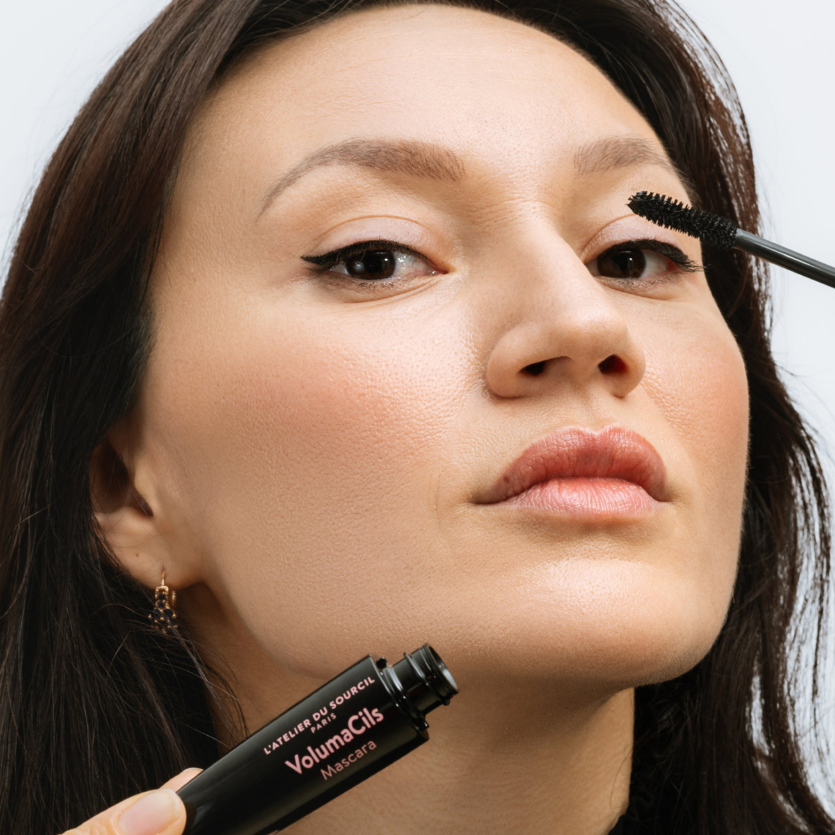 Application du VolumaCils sur les cils, flacon tenu en main, mascara volume L'Atelier du Sourcil